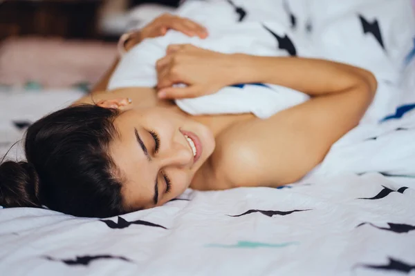 Menina bonita está dormindo. Ela está acordando e sorrindo . — Fotografia de Stock