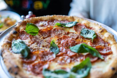 Sosisli ve fesleğenli pizza, yakın görüş.