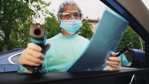 Medico donna uso pistola termometro a infrarossi per controllare la temperatura corporea — Video Stock