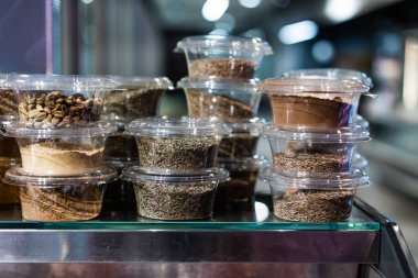 çeşitli baharatlar ve bitkiler küçük şeffaf plastik kutularda paketlenmiştir.