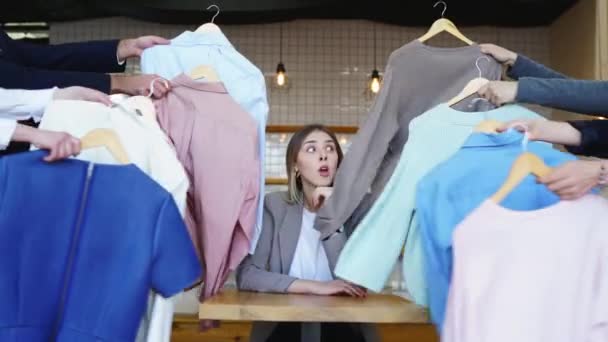 Jovem estilista olhando através do conjunto de camisas para tiro de moda — Vídeo de Stock