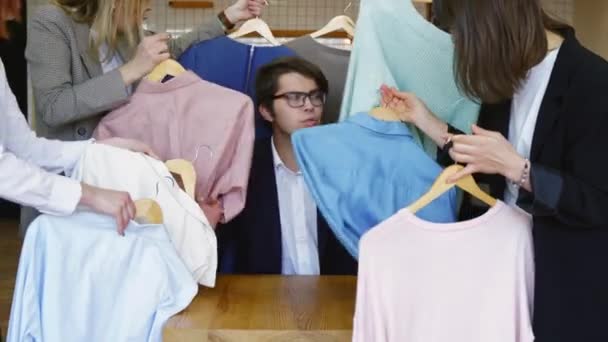 Jovem estilista olhando através do conjunto de camisas para tiro de moda — Vídeo de Stock