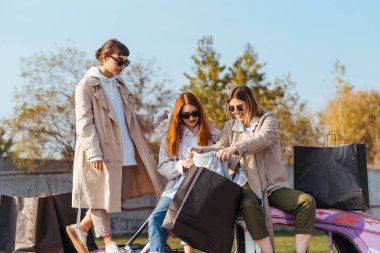 Süslü arabada poz veren genç kadınlar.