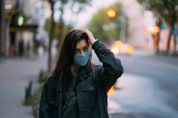 Молодая женщина, человек в защитной стерильной маске на пустой улице — стоковое фото