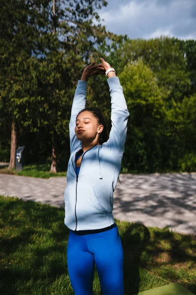 Girl in sports uniform warming up before jogging
