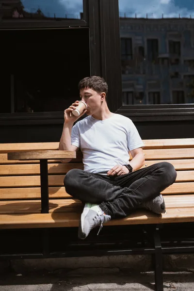 Brunette man in straat cafe drinkt koffie. — Stockfoto