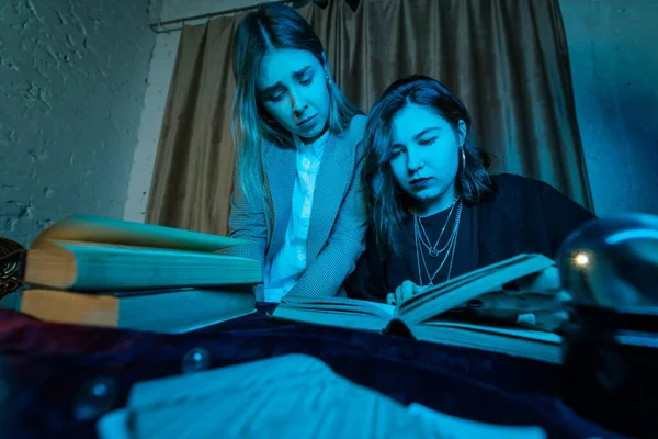 Two women are reading a mysterious book — Stock Photo, Image