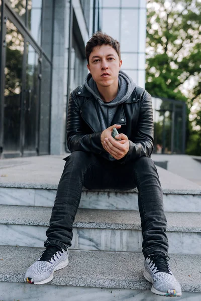 Schöner Kerl sitzt auf der Treppe. — Stockfoto