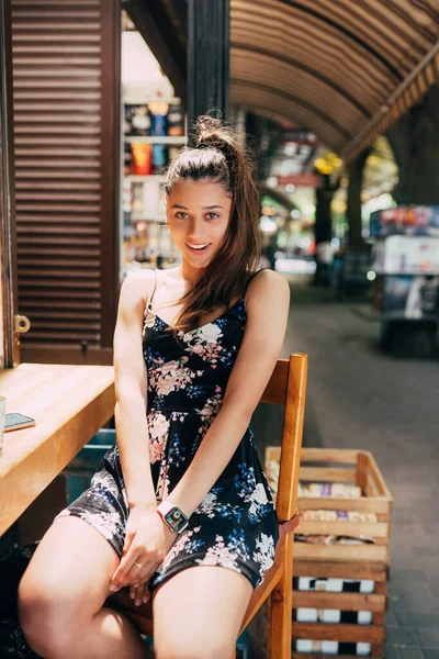 거리 카페에 앉아 있는 매력적 인 젊은 코카 시안 여성 — 스톡 사진
