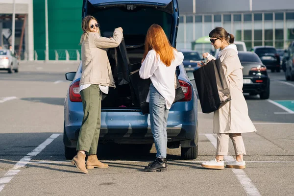 차에서 쇼핑백을 든 젊은 여자들 — 스톡 사진