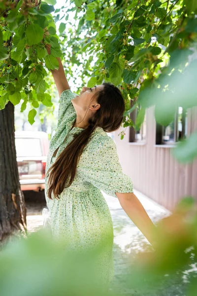 Young woman eating mulberry pluck it from tree. — Stock Photo, Image