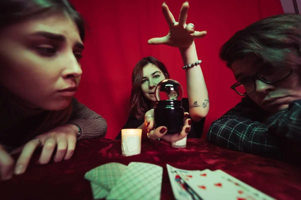 Grupo de pessoas e mulher cartomante com bola de cristal — Fotografia de Stock