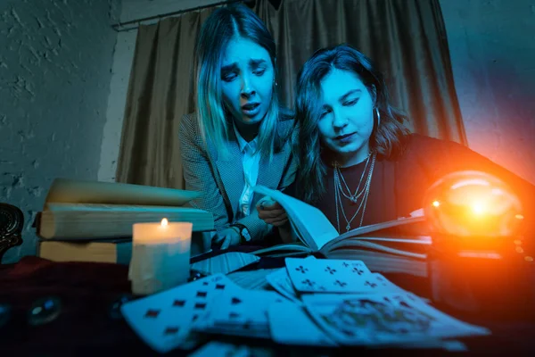 Two women are reading a mysterious book — Stock Photo, Image