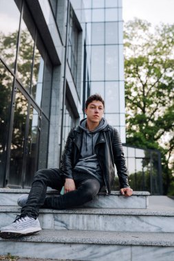 Yakışıklı adam merdivenlerde oturuyor..
