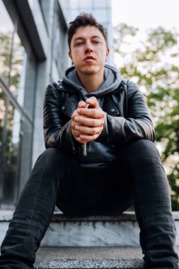 Yakışıklı adam merdivenlerde oturuyor..