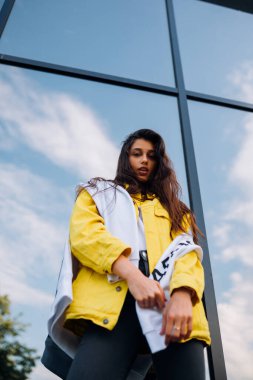 Güzel bir genç kadının dışarıda eğlenip poz verirken portresi..