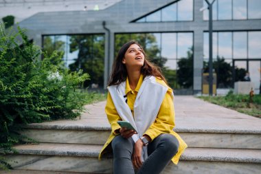 Güzel bir genç kadının dışarıda eğlenip poz verirken portresi..