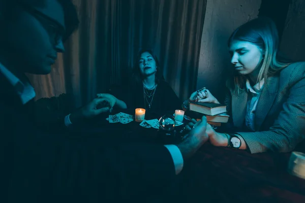 La gente toma las manos de la noche en la mesa con velas — Foto de Stock