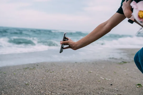 女性は海の波をスマートフォンで撮影 — ストック写真