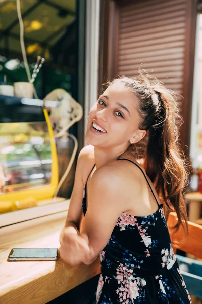 Attractive young caucasian woman sitting in street cafe — Stock Photo, Image