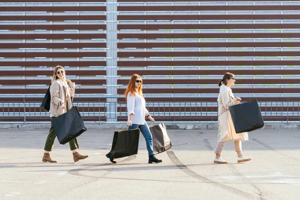 쇼핑백을 들고 거리를 걷고 있는 젊은 여자들. — 스톡 사진