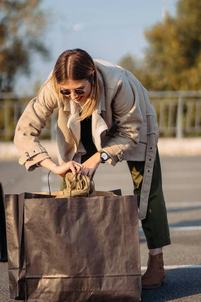 Mladá žena s nákupními taškami na parkoviště — Stock fotografie