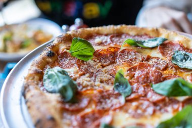 Sosisli ve fesleğenli pizza, yakın görüş.