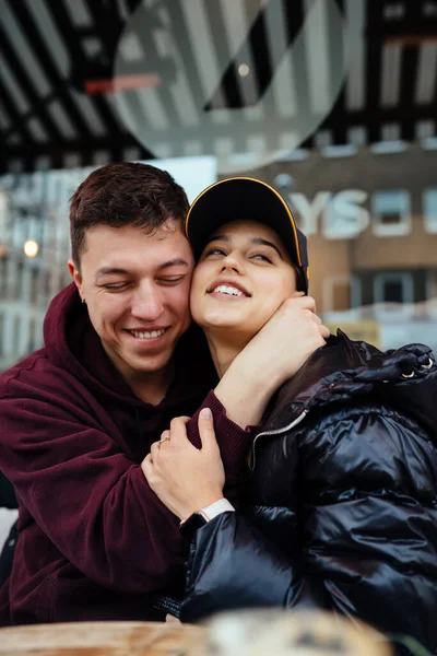 Guy och en tjej kramas vid ett bord på ett uteservering. — Stockfoto