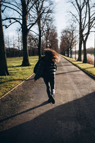 Portrait d'une fille brune s'amusant dans un parc aux rayons du soleil. — Photo
