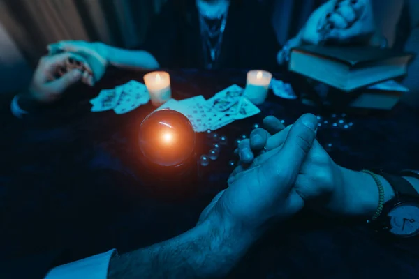La gente toma las manos de la noche en la mesa con velas — Foto de Stock