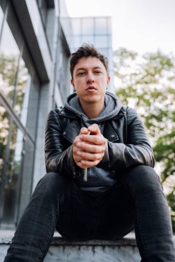 Yakışıklı adam merdivenlerde oturuyor..