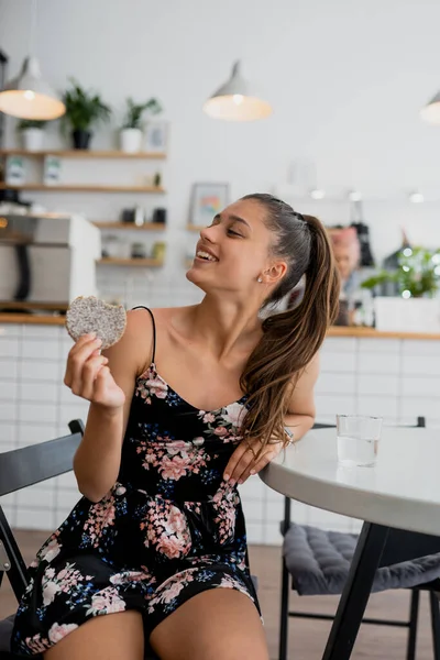 Glad leende flicka håller kakan i ett mysigt café. — Stockfoto