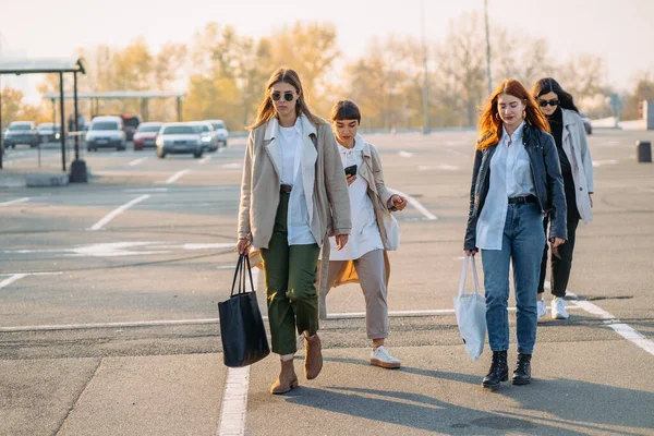 Mladé ženy s nákupními taškami chůze na ulici. — Stock fotografie