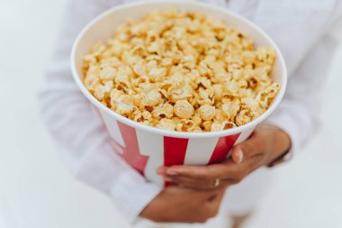 Elinde patlamış mısırla gezen genç bir kızın yakın plan fotoğrafı..