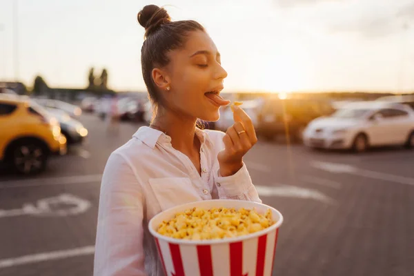 Jonge leuke vrouw met popcorn in een winkelcentrum parkeerplaats — Stockfoto