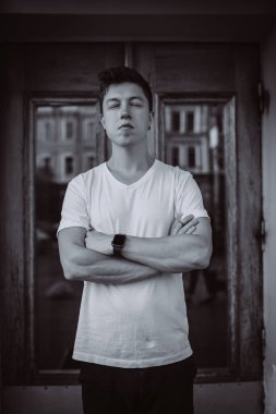 Adam binanın arka planında duruyor, kameraya bak ve etrafına bak.