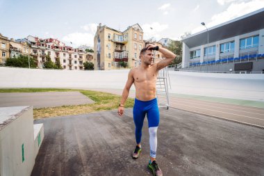 Açık hava spor salonunda çıplak gövdeli kaslı bir adam..