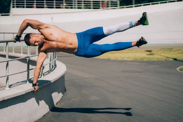 Jeune homme athlétique effectue des éléments de gymnastique - drapeau humain. — Photo