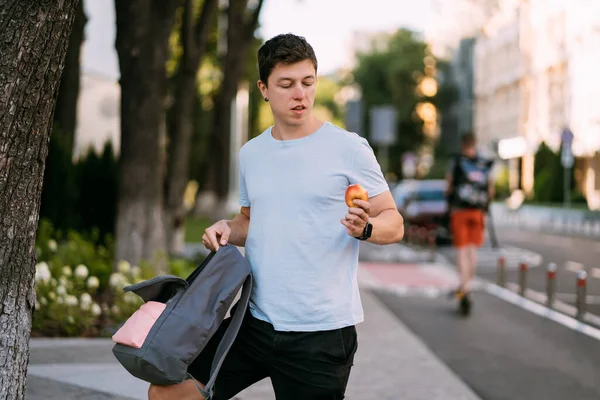 Молодий чоловік тримає яблуко на вулиці — стокове фото