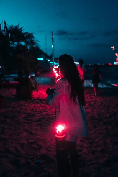 Νεαρή γυναίκα με φεγγίτη στην παραλία τη νύχτα — Φωτογραφία Αρχείου