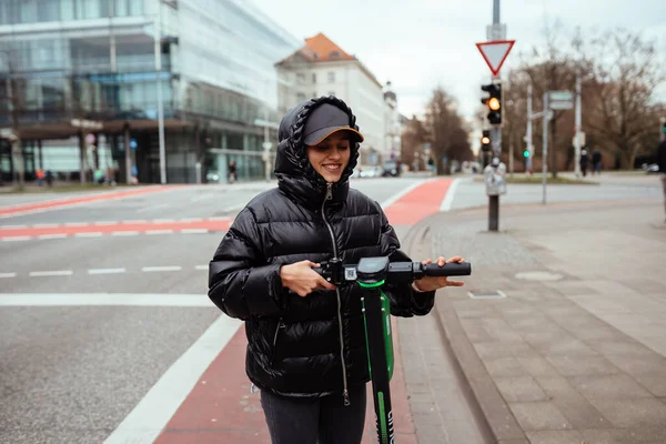 Mooie jonge vrouw paardrijden een elektrische scooter, straat-stijl — Stockfoto