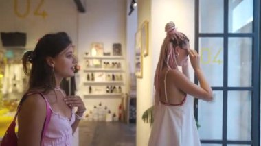 İki şık kız alışveriş çılgınlığının tadını çıkarıyorlar. Moda bir mağazada eşsiz ve modaya uygun eşyalar keşfediyorlar.