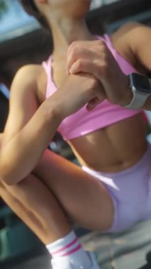 Enerjik bir çekim dinamik bir çömelme pozisyonunda bir fitness tutkununu yakalıyor, atletik aşınma ve dayanıklılık gösteriyor..