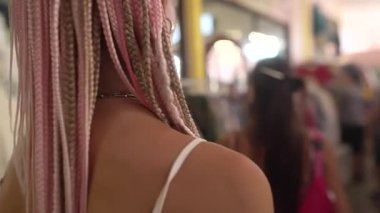 İki kadın kendilerini canlı bir giyim mağazasına daldırıyor, modern moda tarzlarının çeşitliliğini sergiliyorlar.