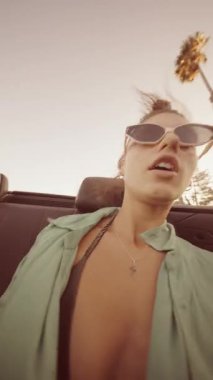 Şık güneş gözlüklü, sallanan palmiye ağaçlı, kaygısız anılarımızı yakalayan hareketli bir yolculuk sahnesi.