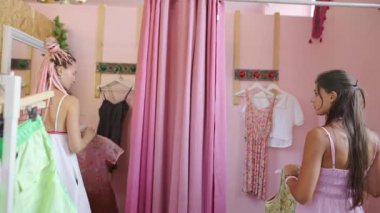 İki yakın arkadaş canlı ve renkli bir soyunma odasında değişik kıyafetler denerken harika vakit geçiriyorlar.