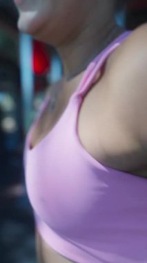 Ağırlıklarla egzersiz yapan, gücünü ve bağlılığını parlak bir çalışma ortamında sergileyen bir kadın..