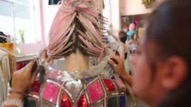 Canlı ve dinamik bir sahne canlı kıyafetler ve neşeli etkileşimlerle dolu bir tryon seansı sergiliyor.