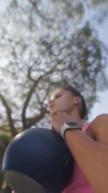 Kettlebell egzersizlerinin yanı sıra şık bir spor kıyafeti sergileyen çekici ve canlandırıcı bir açık hava egzersizi.