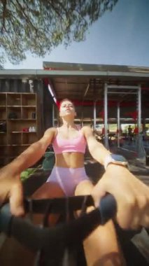 Kararlı genç bir kadın yoğun bir şekilde açık havada kürek çekiyor, olağanüstü gücünü ve bağlılığını gösteriyor.